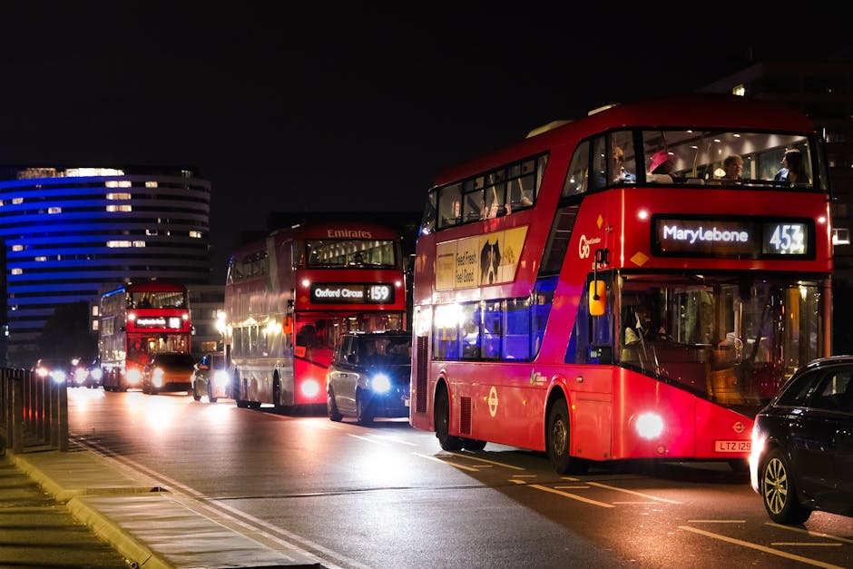 A red double-decker bus displaying the route number 453 and destination Marylebone is traveling along a city street illuminated by natural daylight. The bus features large front windows with reflections of surrounding buildings and people. In the background, there are historic multi-story buildings with ornate architectural details, tall windows, and balconies, indicating a typical London streetscape. The street is relatively quiet with a pedestrian walking on the pavement near the bus and other vehicles possibly out of view. The scene captures the typical urban environment where home relocation services by Movers Marylebone may involve coordinated furniture transport and moving logistics, with the bus potentially providing transportation for residents or serving as a reference point for nearby property access during a removal or house move in the W1 area.